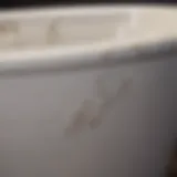 Close-up view of a porcelain tub with visible chips and scratches