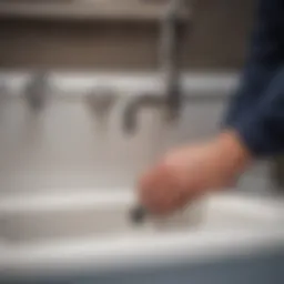 A plumber installing the sink drain pipe