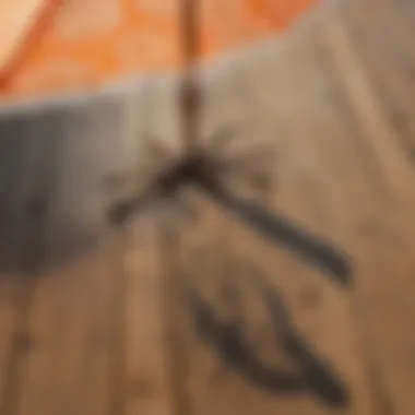 Orange and white patio umbrella casting a patterned shadow on a wooden deck