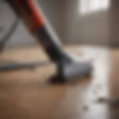 Close-up of a handheld vacuum cleaner nozzle picking up debris